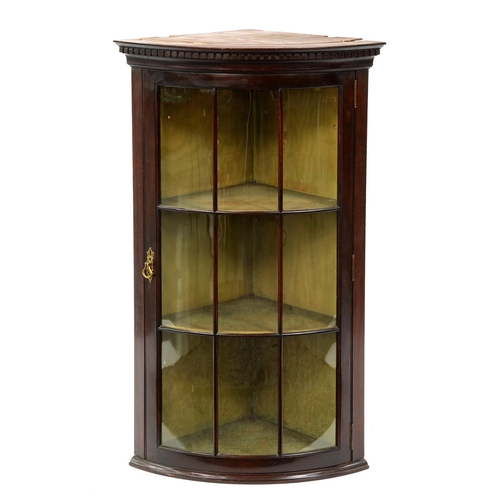 1280 - A bow fronted mahogany hanging corner cabinet, early 20th c, with dentil cornice and glazed nine pan... 