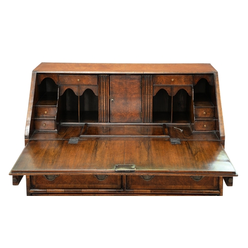 1214 - A walnut and crossbanded bureau, c1930, in Queen Anne style, the stepped, fitted interior with well,... 