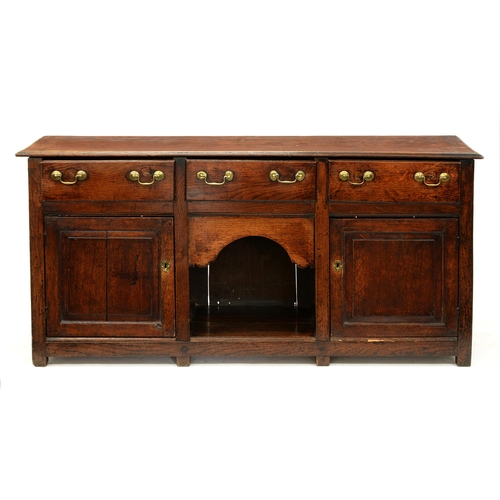 1221 - A George III oak dresser with three drawers, open centre and pair of square doors with raised and fi... 