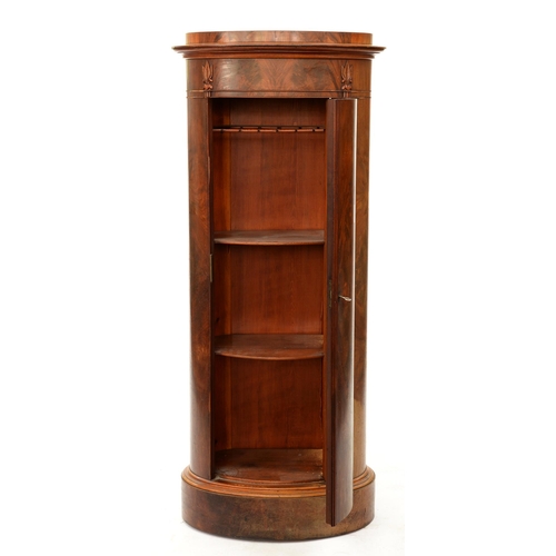 1227 - A Northern European Biedermeier style mahogany cupboard, 19th c, of oval section, the curved door is... 