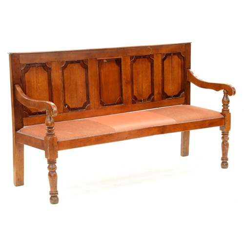 1257 - A Victorian varnished and stained oak and mahogany settle, the back with five crossbanded panels, on... 