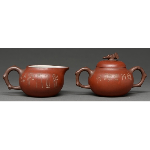 396 - A Chinese earthenware cream jug and sugar bowl and cover, 20th c, incised with Chinese characters, w... 