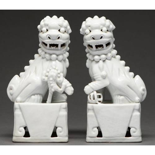 486 - A pair of blanc de chine dogs of Fo, late 20th c, 28.5cm h (2)