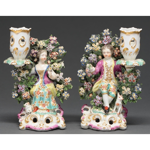 551 - A pair of Derby candlesticks modelled with figures of man and woman before bocage, first half of 19t... 