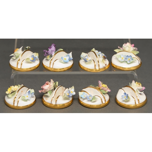 567 - A set of eight Royal Crown Derby floral encrusted menu or place stands, 20th c,  3.4cm diam, printed... 