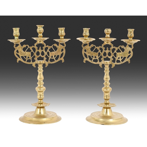 670 - A pair of Middle Eastern pierced brass three-branch candelabra, on turned base, 42cm h... 