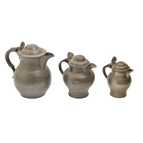 770 - Three English pewter gin or water jugs, 19th c,  with domed lid and anthemion thumbpiece, 20-27cm h... 