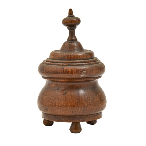 827 - Treen. A Victorian turned oak jar and cover, on three peg feet, 16cm h