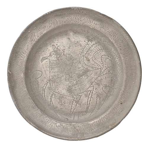 831 - An English pewter wrigglework bird plate, late 17th c,  21.5cm diam, marks rubbed, engraved with con... 