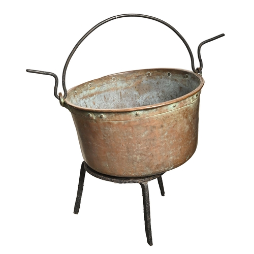 868 - A copper vat, early 19th c, with iron swing handle, on iron tripod stand, 47cm diam... 