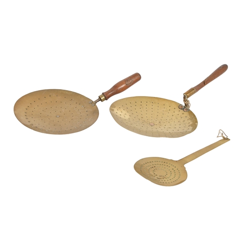 883 - Two pierced brass cream skimmers, late 19th/early 20th c, with turned wood handles, 24cm and 23cm di... 