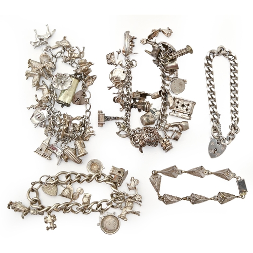 90A - Three silver charm bracelets, a silver curb bracelet and padlock and a silver filigree bracelet, var... 