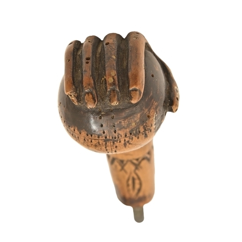 822 - An American carved and stained wood walking cane handle, early 20th c, in the form of a hand holding... 