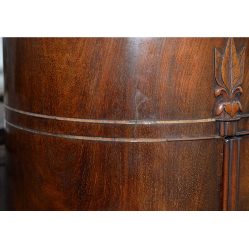 1227 - A Northern European Biedermeier style mahogany cupboard, 19th c, of oval section, the curved door is... 