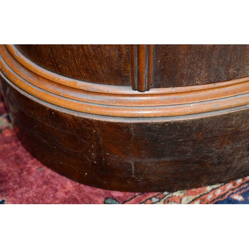 1227 - A Northern European Biedermeier style mahogany cupboard, 19th c, of oval section, the curved door is... 