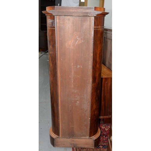 1227 - A Northern European Biedermeier style mahogany cupboard, 19th c, of oval section, the curved door is... 