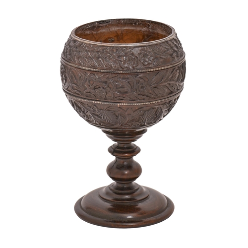 586 - A coconut cup,  possibly French late 18th c, the bowl carved in three registers with trailing f... 