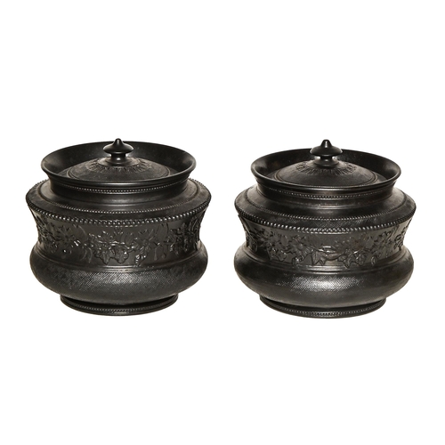 334 - A pair of black basalt tobacco jars and covers, c.1820, attributed to Charles Bourne, sprigged with ... 