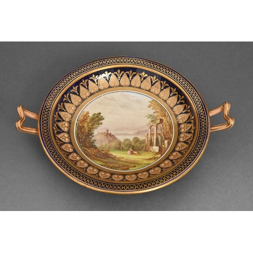 48 - A two handled porcelain dish, c1820, enamelled with a central scene, the rim gilt on a cobalt blue a... 