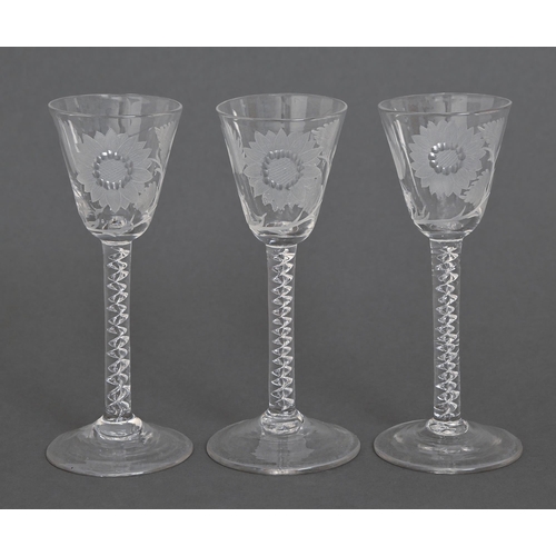 63 - Three wine glasses, 19th c, the bowl etched with a flower, on multiple series air twist stem, 15cm h... 