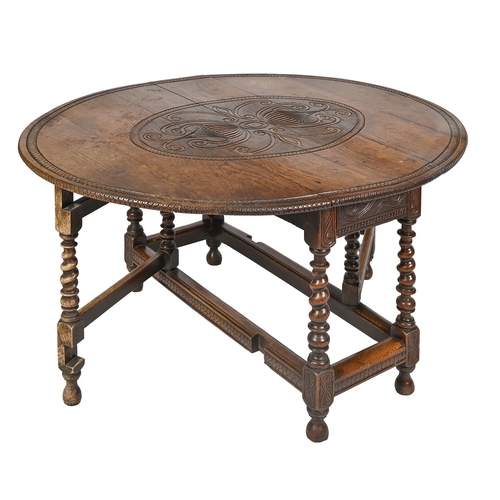 865 - An oak gateleg table, 18th c, the carving of later date, 76cm h; 122 x 140cm