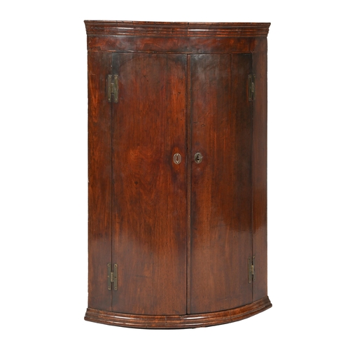 879 - A George III bow fronted mahogany hanging corner cupboard, 107cm h; 45 x 66cm