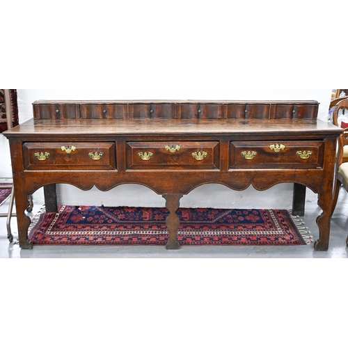 887 - A George III oak dresser, the two-plank top surmounted by a row of serpentine spice drawers, having ... 