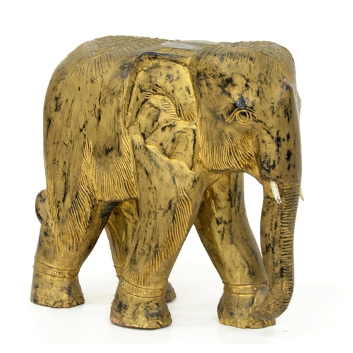 1005 - A carved and gilded hardwood sculpture of a caparisoned elephant, Thailand, 20th c, with green and s... 