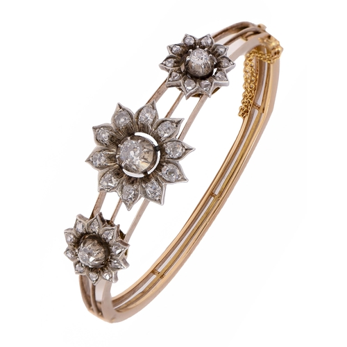 102 - A Victorian diamond bangle, with three sunflower shaped diamond clusters, in silver on gold bangle, ... 