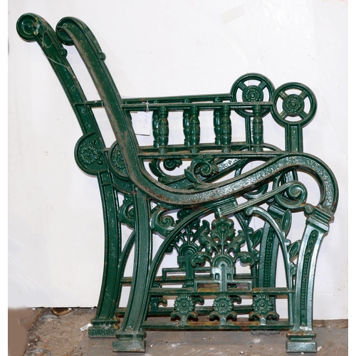 1067 - A pair of green painted cast iron garden bench ends, early 20th c