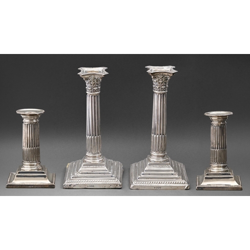 323 - A pair of Edwardian silver candlesticks, the stop fluted pillar on stepped square foot, nozzles, 21c... 