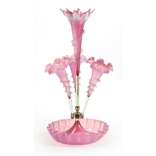 476 - A Victorian pink semi-opalescent glass flower stand, of one central and three detachable vases with ... 