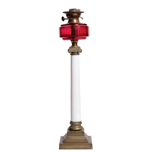 633 - A Victorian Corinthian style oil lamp, with white brass column, cranberry glass font and twin burner... 