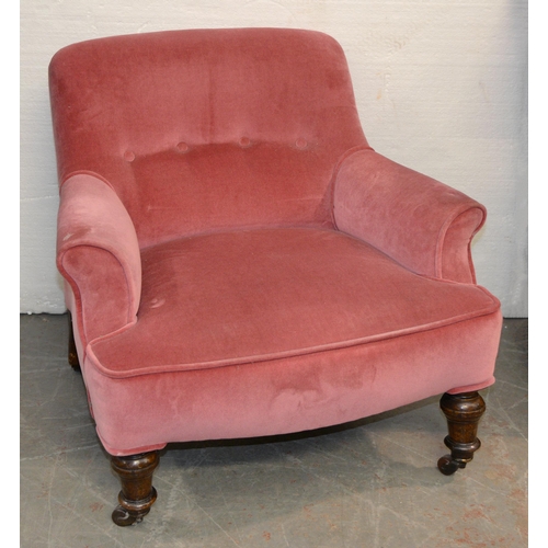 1061 - A Victorian mahogany armchair on turned front legs and pottery castors, covered in pink button back ... 