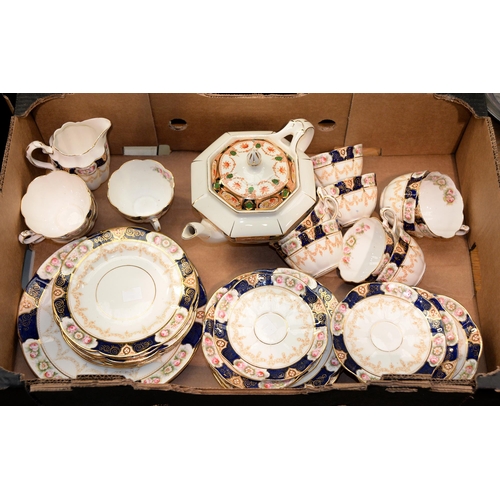 1097 - A William Lowe bone china tea service, pre-1912, the cobalt border reserved with panels of roses, pr... 