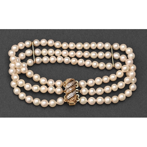 177 - A cultured pearl bracelet, with gold spacers, of three strands of 5mm cultured pearls with diamond a... 