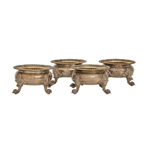 552 - A set of four George II silver gadrooned oval salt cellars, on four scaly scroll feet, crested, 10cm... 