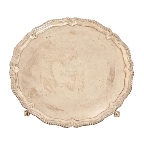 559 - A George III silver salver, with gadrooned rim, on claw and ball feet, engraved with crest and motto... 