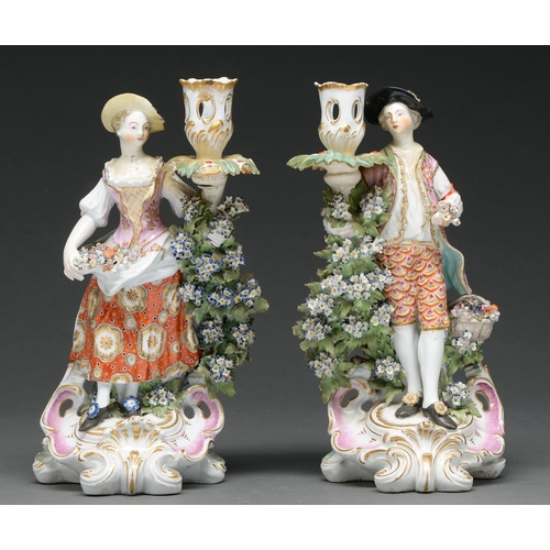 611 - A pair of Derby figural candlesticks, c 1770, of a lady and her gallant as a shepherd and shepherdes... 