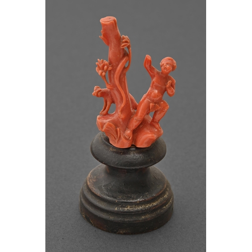 738 - A Trapani miniature coral carving of Putto and a hound by a tree, early 18th c, 58mm h excluding woo... 