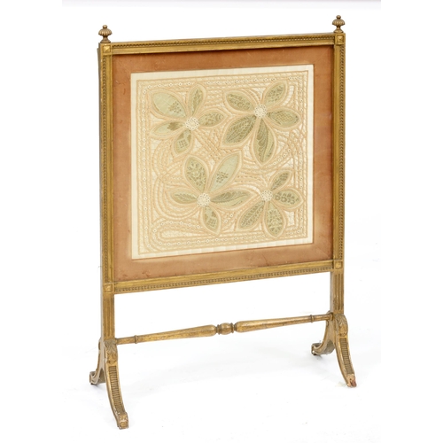 1212 - A giltwood firescreen, c1900, the silk covered back with magazine wallet, glazed needlework banner, ... 