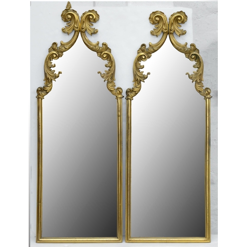 1056 - A pair of gilt brass mirrors, early 20th c, crested by leafy scrolls and volutes, 84cm h, 32cm w... 