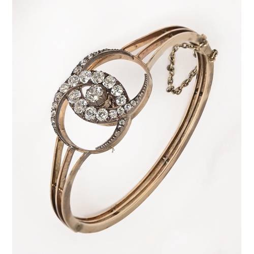 115 - A diamond bangle, c1900, with old cut diamonds, the two entwined crescents demountable for wear as a... 