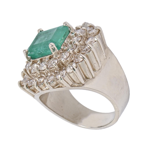 47 - An emerald and diamond ring, with approx 8.5 x 10mm step cut emerald in two tier surround of round b... 