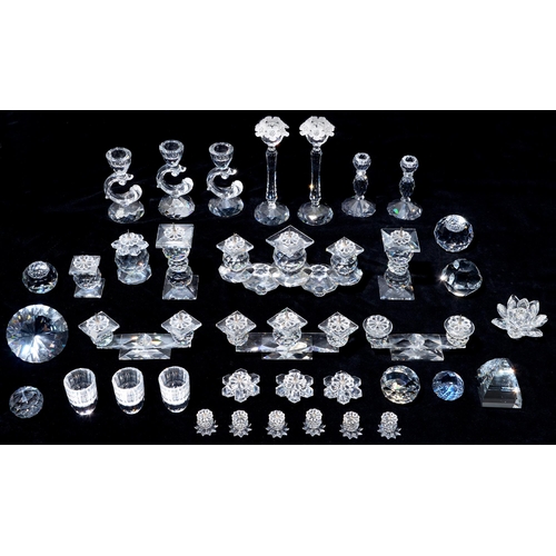 523 - Swarovski. A collection of glass candle holders and paperweights, three glasses, stands and pens, bo... 