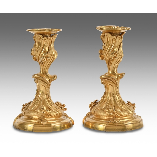 584 - A pair of French ormolu candlesticks, after 18th c models by Juste-Aurele Meissonnier, 19th c, nozzl... 