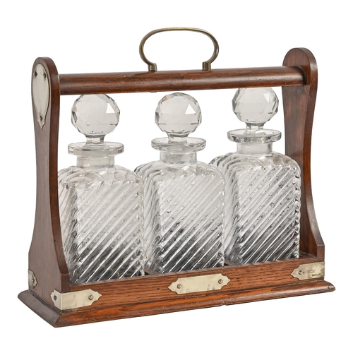 602 - An EPNS mounted oak tantalus and set of three decanters, key, 30cm h