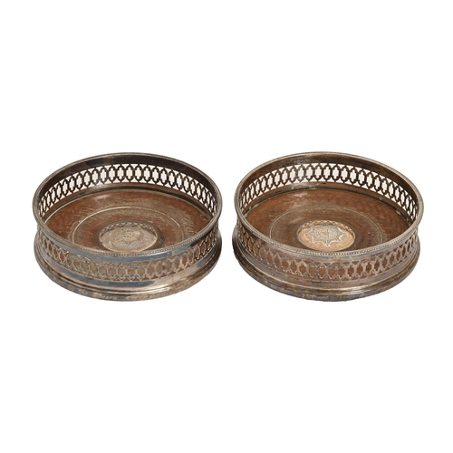 236 - A pair of Elizabeth II pierced silver wine coasters, with beaded rim, inset turned wood base, with s... 