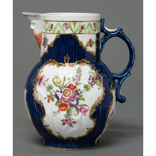 358 - A Worcester scale blue ground cabbage leaf moulded mask jug, c1775, enamelled with flowers, the hand... 