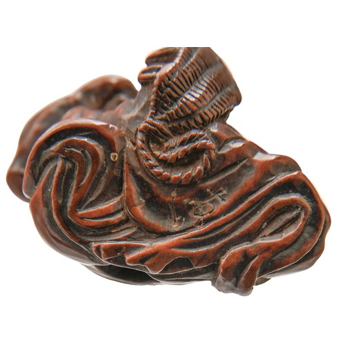 423 - A Japanese wood netsuke of a temple guardian (Nio), 19th/20th c, carrying a large pair of straw sand... 